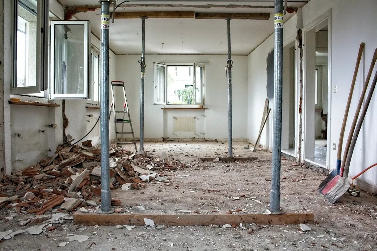 Room stripped back for renovation with exposed walls and debris