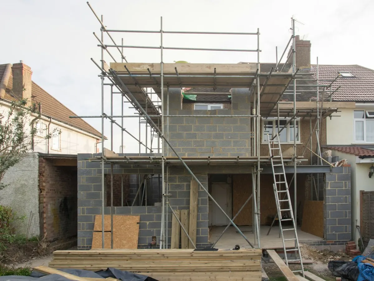 Two-storey house extension under construction with scaffolding