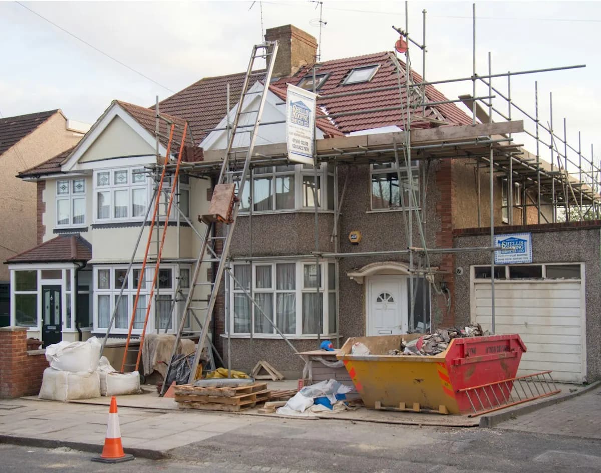 Street view of a house extension work area and material storage